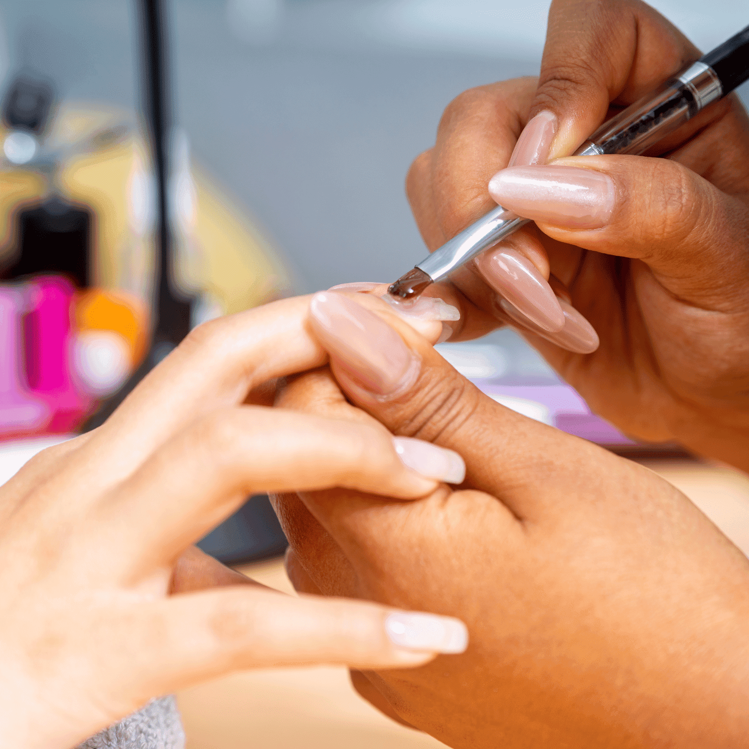 Nail artist applying polish during a manicure session.