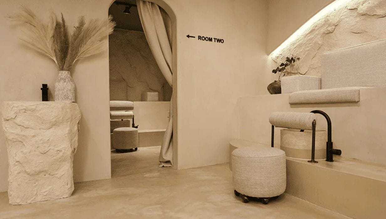 Minimalist interior with a neutral palette, textured walls, and modern furnishings.